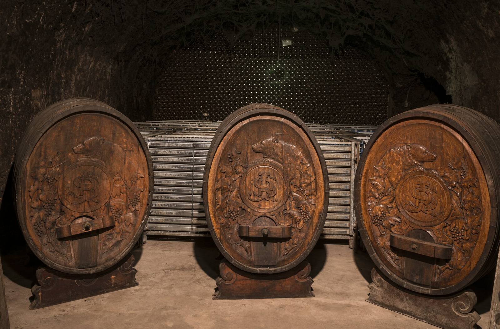 Oak barrels aging in a Napa Valley wine cellar. Surplus premium wine across California is being sold in bulk and bottled under retailers' private labels as the industry works through a historic inventory overhang.