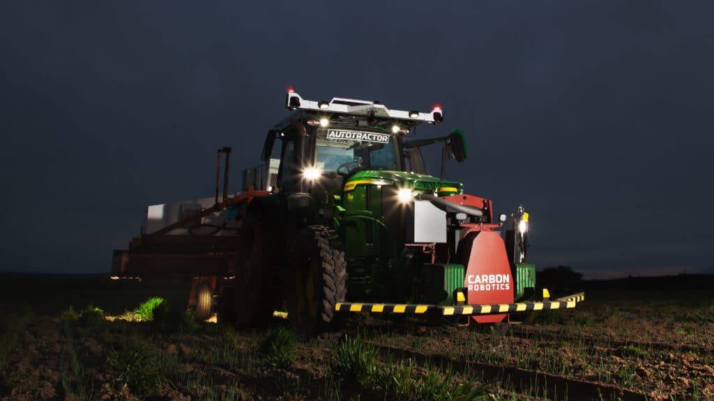 Carbon Robotics' autonomous tractor platform, marketed as the Carbon AutoTractor, working a field at night. The Carbon Autonomy Ready program, announced September 1, 2026, lets third-party implement makers connect equipment directly to the system.